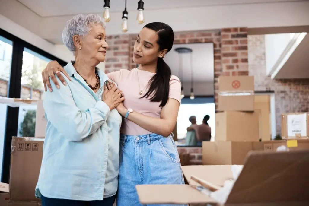 Retired homeowner and her adult daughter packing boxes while downsizing to a new home