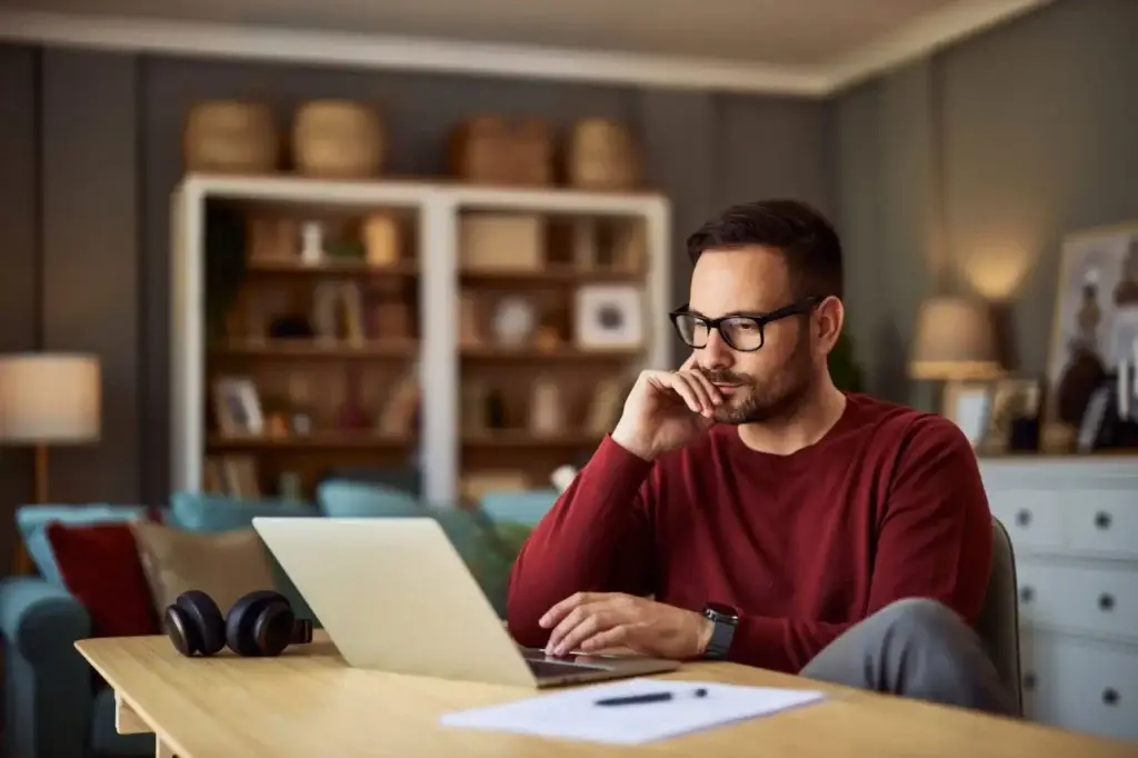 Homeowner at a desk comparing 15 year and 30 year mortgage payments on a laptop